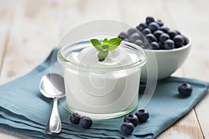 plain yogurt in a ceramic bowl with a silver spoon