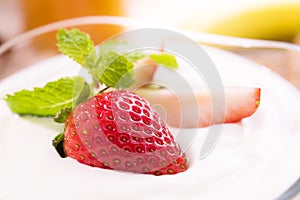 Plain yogurt with fresh strawberry on top in bowl on the table