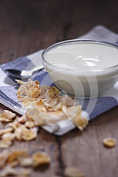 Plain yogurt in small glass bowl with crispy cereal