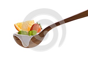 Plain yogurt on a spoon with fresh fruits on top isolated on white background