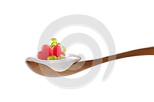 Plain yogurt on a spoon with fresh heart shape watermelon on top isolated on white background