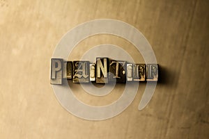 PLAINTIFF - close-up of grungy vintage typeset word on metal backdrop photo