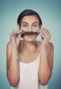 Plaits also make for great moustaches. Studio shot of a beautiful young woman posing against a green background.