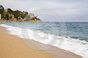 Plajan on the Costa Brava and city beach in Lloret de Mar, Spain. Sand and sea waves.