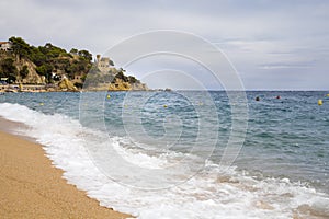 Plajan on the Costa Brava and city beach in Lloret de Mar, Spain. Sand and sea waves.