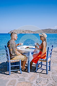 Plaka Lassithi with is traditional blue table and chairs and the beach in Crete Greece