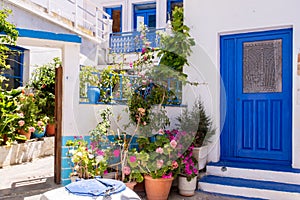 Plaka Town on Milos Island - picturesque narrow stone street with traditional greek whitewashed walls, blue doors, Greece