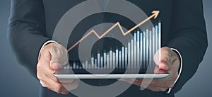 Plan graph growth and increase of chart positive indicators, tablet in hand