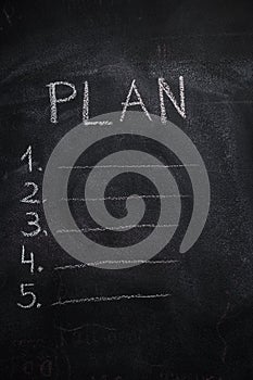 Plan list on black chalkboard