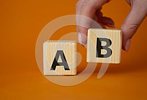 Plan A and Plan B. Businessman hand is making a choice between Plan A and Plan B symbol. Beautiful orange background. Business