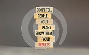 Plan or result symbol. Concept words Do not tell people your plans show them your results on wooden block. Beautiful grey table