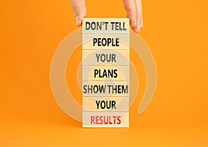 Plan or result symbol. Concept words Do not tell people your plans show them your results on wooden block. Beautiful orange table