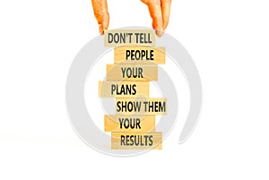 Plan or result symbol. Concept words Do not tell people your plans show them your results on wooden block. Beautiful white table