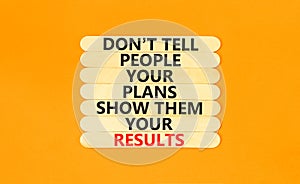 Plan or result symbol. Concept words Do not tell people your plans show them your results on wooden stick on beautiful orange