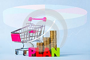 PLAN wooden text and step of stacks of coins with shopping cart