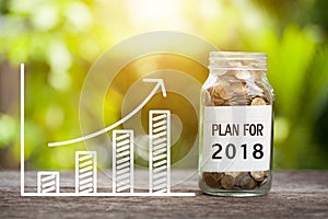 Plan For 2018 Word With Coin In Glass Jar and graph up.