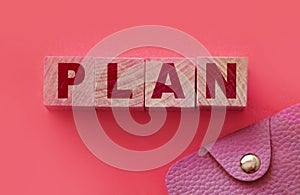 PLAN word made with building blocks on pink and small wallet. Financial planning finace management concept photo
