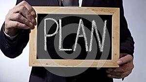 Plan written on blackboard, businessman holding sign, business concept, strategy