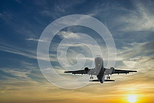 The plane against the blue sunset sky. The setting sun