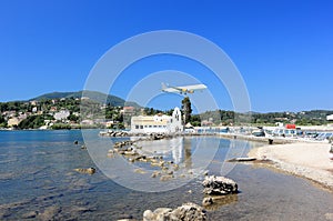 Plane approaching Corfu airport over Vlacherna monastery. Kanoni peninsula, Corfu island, Ionian Sea, Greece.