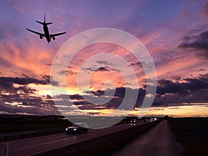 A plane is approaching Stuttgart AIrport during a dramatic sunset