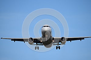 Commercial airplane in flight approaching airport runway.