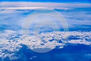 Plane of commercial flights crossing a sky of blue and white clouds seen from above, on the Mediterranean