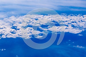 Plane of commercial flights crossing a sky of blue and white clouds seen from above, on the Mediterranean