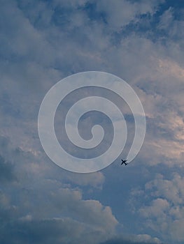 Plane crosses a blue cloudy sky