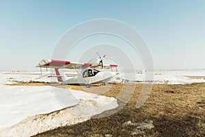 the plane is in the field. Crop duster in a field with melting snow.