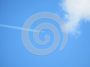 The plane flies against a clear blue sky