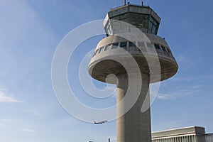 A plane flies next to the control tower at Barcelona Airport, Sp