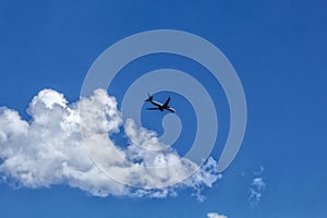 The plane flies in the sky with clouds. photo