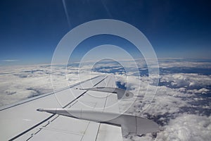 Plane flying above the clouds on a beautiful blue sky