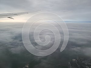 Plane flying between cloud layers viewed from passenger cabin