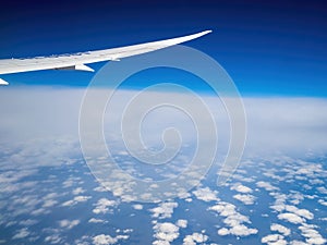 Plane flying between cloud layers viewed from passenger cabin window