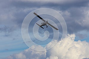 Plane flying on cloudy sky from side. Aviation background