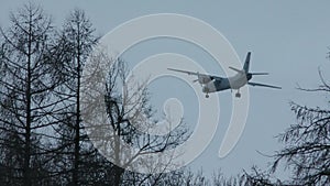 The plane is flying in the gloomy sky.