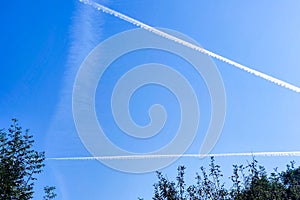 Plane flying high in the sky. clear blue sky with vapor trails background