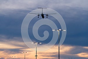 Plane flying low over parking lot while sunset