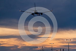 Plane flying low over parking lot while sunset