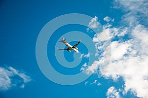 the plane is flying to cloud blue sky from ariport among sunlig