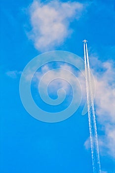 Plane Flying with Trails blue sky