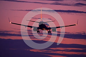 Plane flying up in the pink mauve sky photo