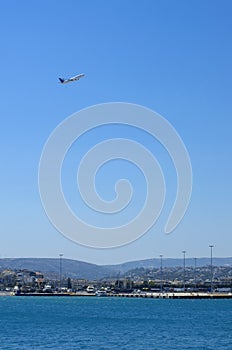 The plane is gaining altitude in the blue sky