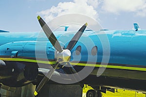 Plane on a green field with blue sky in the background.