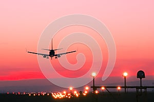 Plane lands at an airfield at the sunset