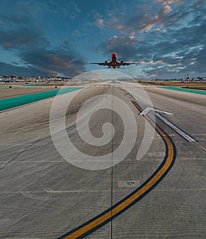 Plane Landing on Runway at Sunset