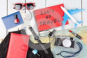 plane, map, passport, money, watch, camera, notepad with text & x22;Let& x27;s go TRAVEL& x22;, sunglasses, wallet