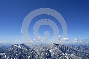 Plane over Watzmann Hocheck mountain, Bavaria, Germany